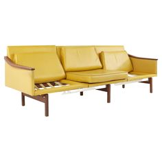 a yellow leather couch with wooden legs