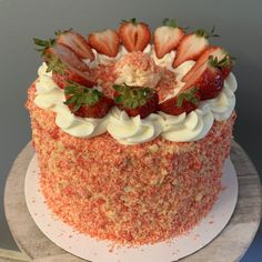 there is a cake with strawberries on top and icing sprinkles