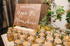 a table topped with lots of jars filled with honey