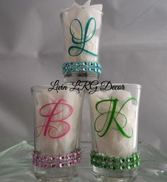 three personalized candles are stacked on top of each other, with the letter k painted on them