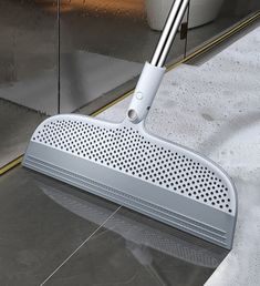 a mop is laying on the floor in front of a glass door with its handle extended