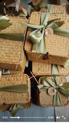 several wicker baskets with green bows and tags on them are stacked up in a pile