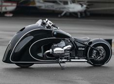 a black motorcycle parked in front of an airplane