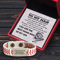 a baseball themed bracelet with the message to my man on it next to a red box