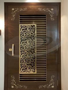 a wooden door with decorative designs on the front and side panels, along with a wall light