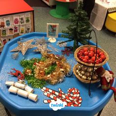 a blue table topped with christmas decorations and candy canes next to a small tree