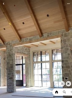 an empty room with large windows and stone pillars on the ceiling is seen in this image