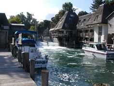 two boats are in the water next to houses and a dock with a boat on it