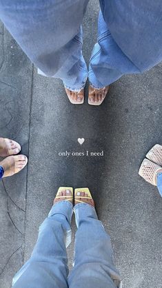 two people standing next to each other with their feet on the ground