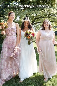 three bridesmaids are standing in the grass together