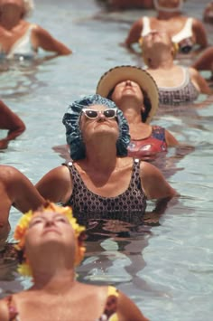 several people in the water with hats and sun glasses