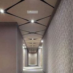 an empty hallway is shown with lights on the ceiling and carpeted walls in front of it