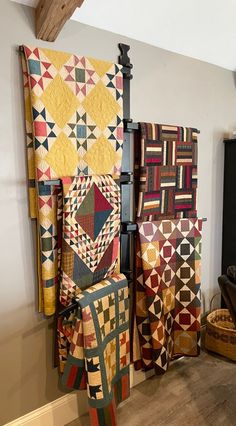 several quilts are hanging on the wall next to each other