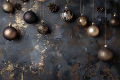 christmas ornaments hanging on a wall with pine cones and other decorations in gold, silver and black