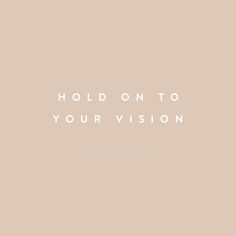 the words hold on to your vision are in white letters against a pale pink background