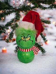 a green christmas ornament with a santa hat on