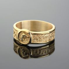 a gold ring with an image of a horse on the front, and a coin in the middle