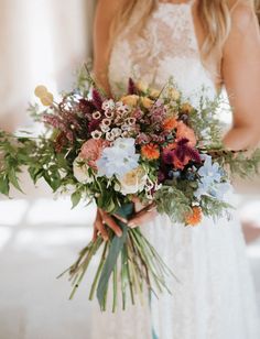 a woman holding a bouquet of flowers in her hands