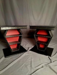 two black and red book cases sitting on top of a bed