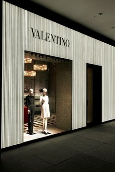 an empty store front with two mannequins in the window