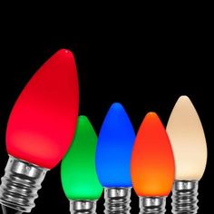 multicolored christmas lights are lined up in a row on a black background,