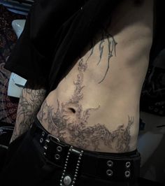 a man with tattoos on his stomach and chest