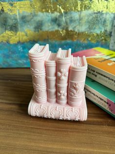 three pink bookends sitting on top of a wooden table