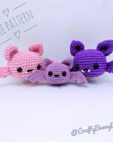 three small crocheted stuffed animals sitting next to each other on a white surface