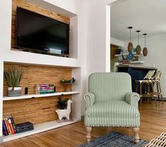 a living room filled with furniture and a flat screen tv mounted on the wall above a fireplace