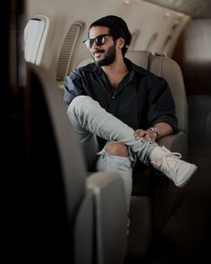 a man sitting on an airplane with his legs crossed