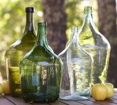 an image of three green glass bottles with lemons on the table next to them