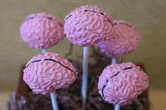 four pink brain shaped lollipops sitting on top of each other in a pot