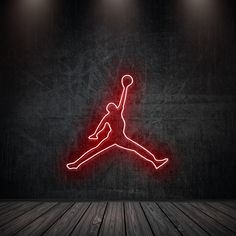 an air jordan neon sign on a wall in a dark room with wooden flooring