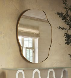 a mirror hanging on the wall above a shelf