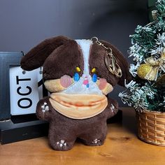 a brown stuffed animal sitting next to a small christmas tree