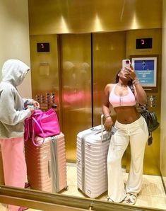 two women standing next to each other with luggage