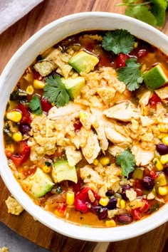 a bowl of chicken tortilla soup with avocado and cilantro