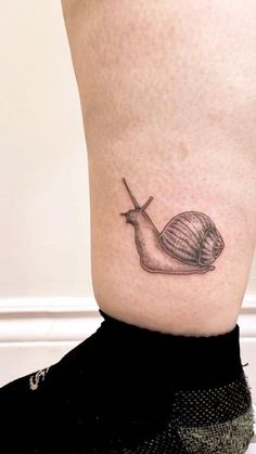 a small snail tattoo on the ankle