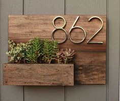 a house number sign with succulents in it