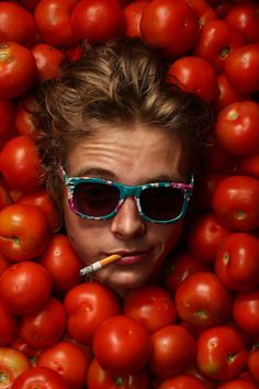 a woman wearing sunglasses is surrounded by tomatoes