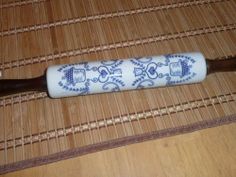 a blue and white toothbrush sitting on top of a bamboo mat