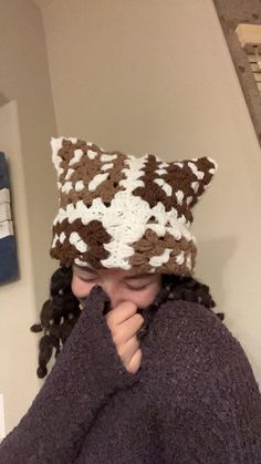 a woman wearing a brown and white knitted hat