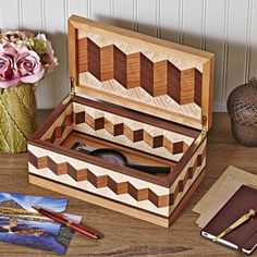 a wooden box sitting on top of a table next to a vase with flowers in it