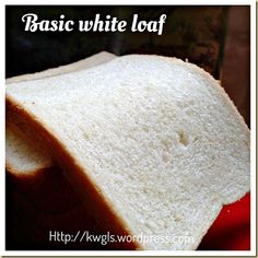 a slice of white bread sitting on top of a red plate with the words basic white loaf