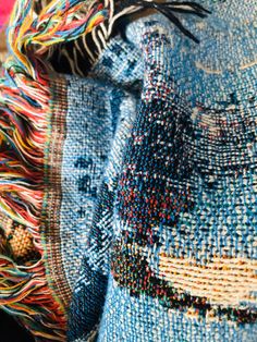 a close up view of a blue bag with fringes on it's sides