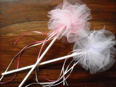 two lollipops with pink and white tulle on them sitting next to each other