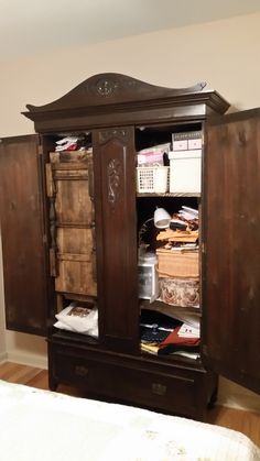 a wooden armoire with drawers in a bedroom