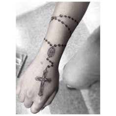 a woman's foot with a rosary tattoo on it