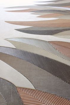 an abstractly designed area rug is shown in brown and beige colors, with wavy lines on the floor