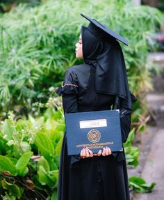 a woman dressed in black holding a plaque